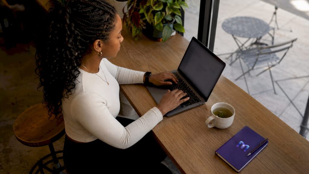 Woman typing on laptop engaging in AI chat interaction