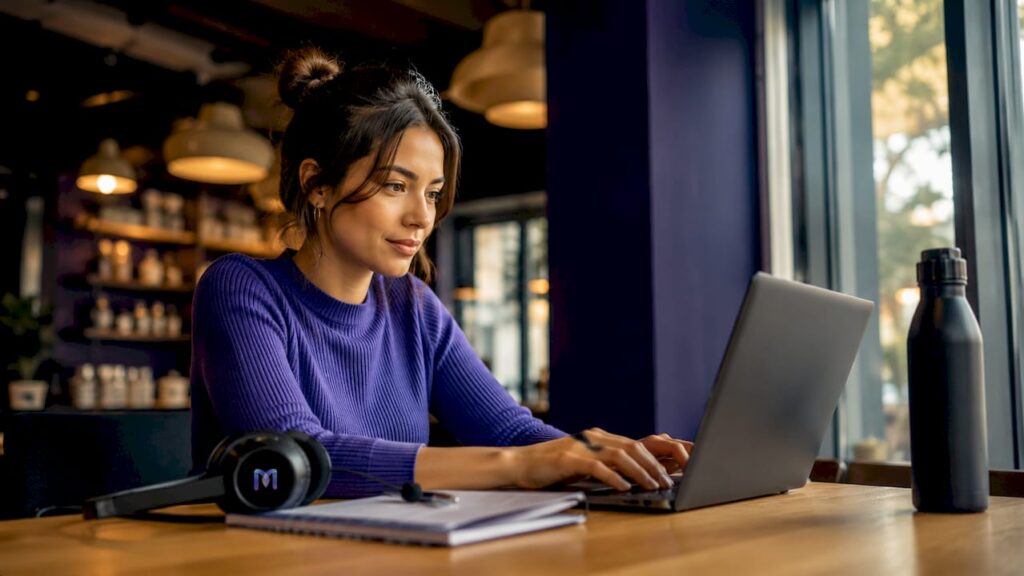 Customer support agent typing at desk with dual monitors
