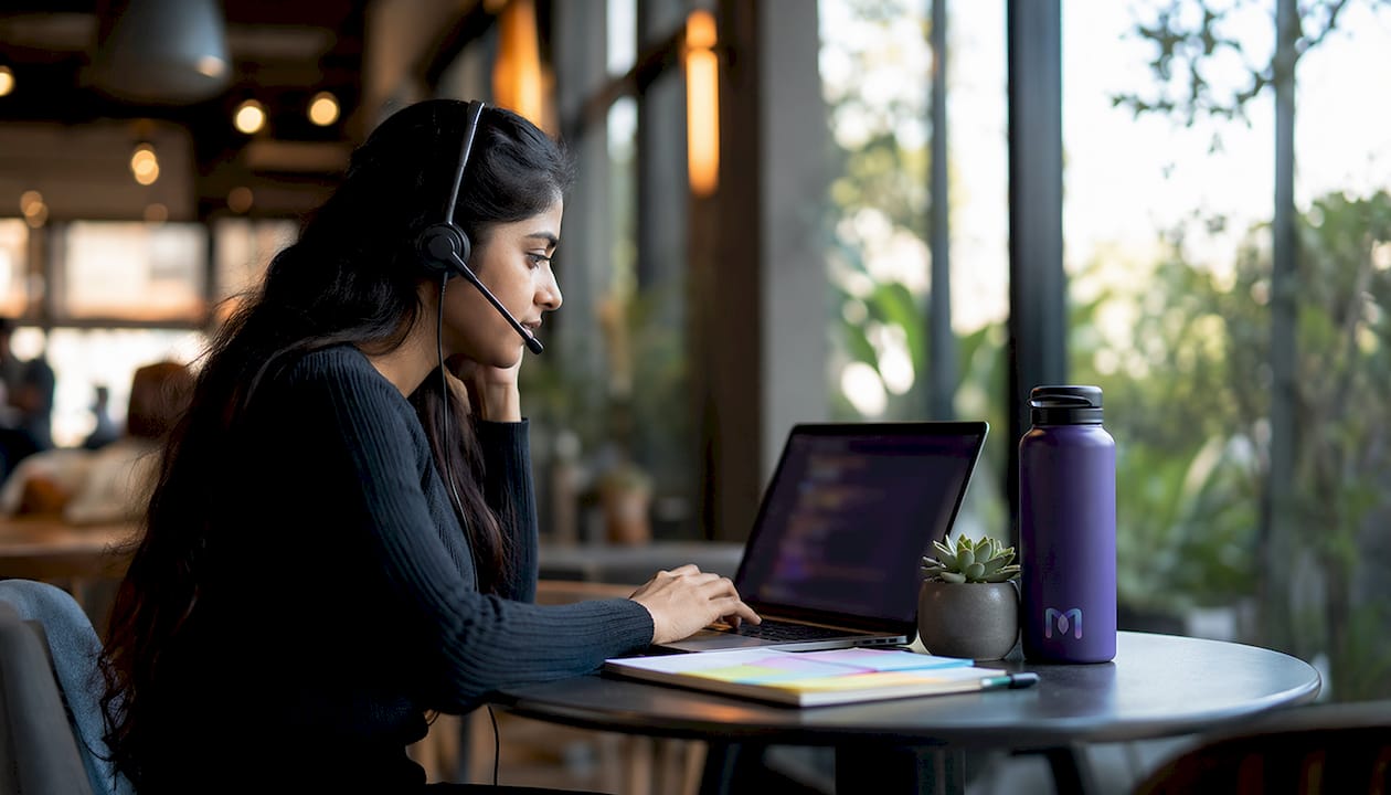 Support agent using AI assist software at desk