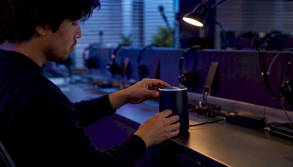 Hands adjusting AI voice assistant device close-up