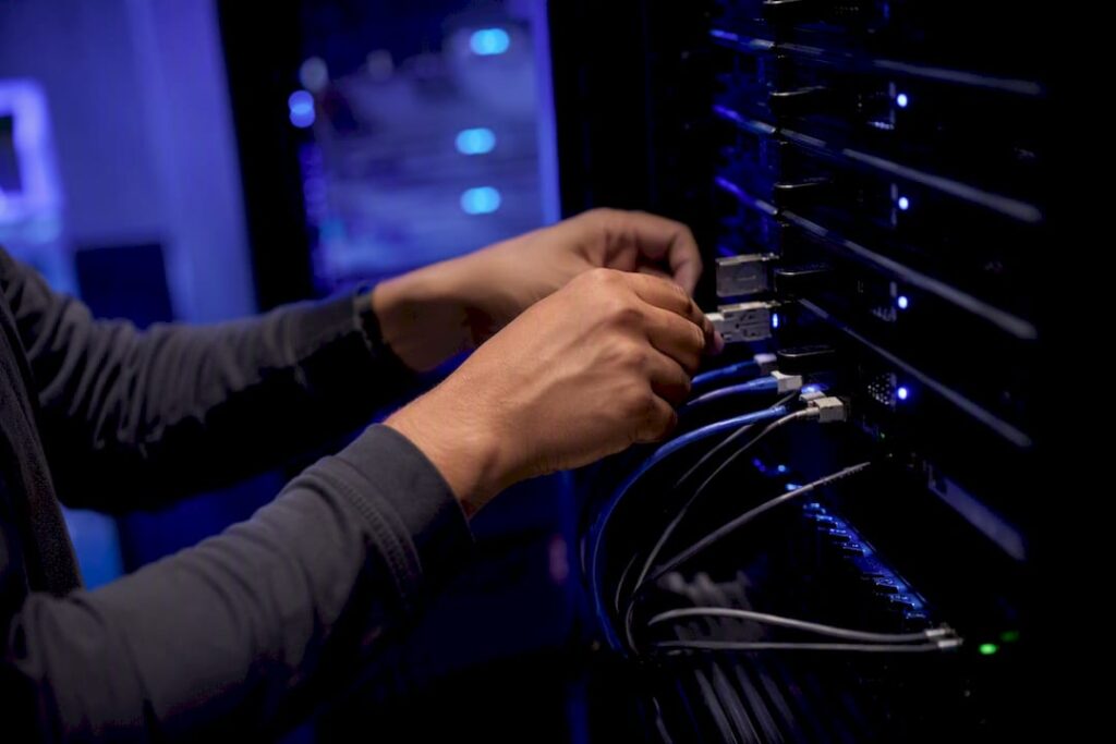 Hands connecting cables in data center