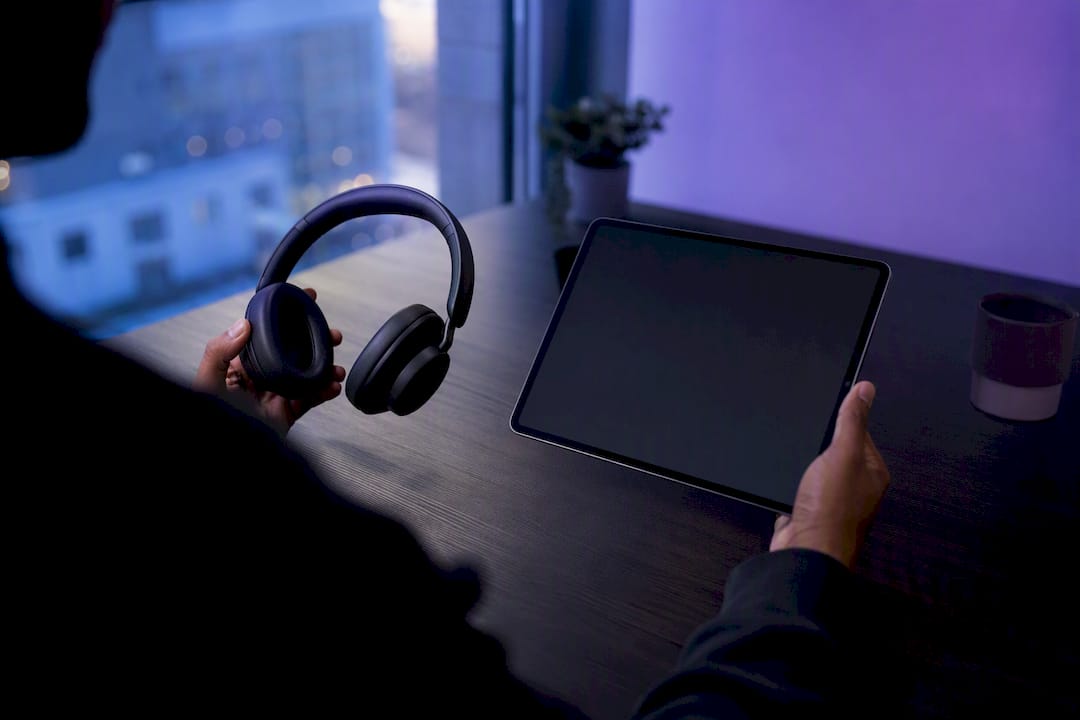 Hands holding smartphone and headset side by side