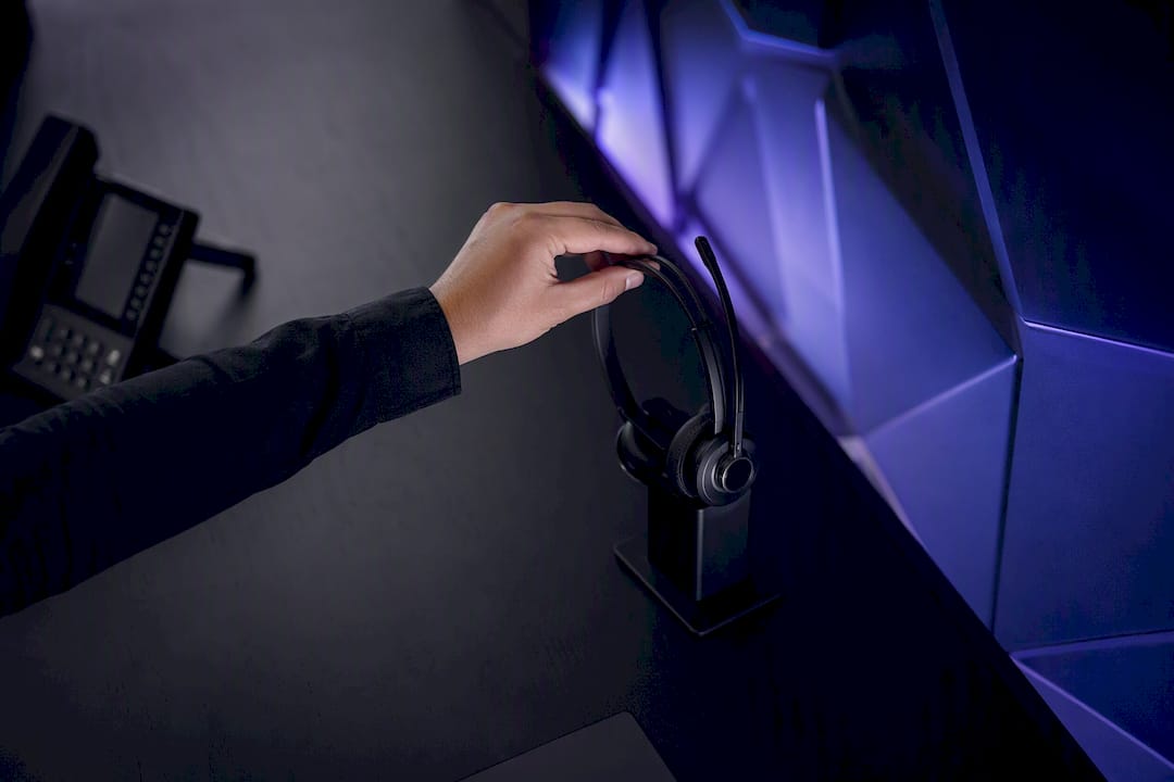 Hand placing headset on charging stand